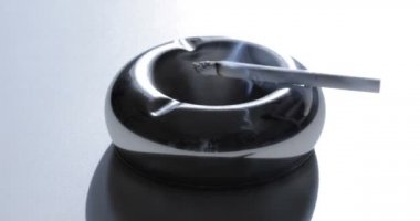 Kül tablasında yanan sigaranın görüntüsünü kapat