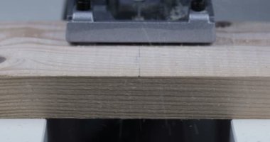 Tahtayı büyük dairesel bir testere ile kesen bir marangoz.