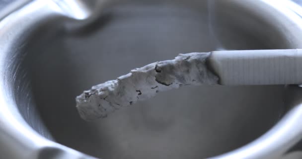 灰皿の中の喫煙タバコのビューを閉じる — ストック動画