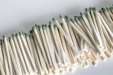 Beyaz arka planda yeşil başlı bir yığın kibrit.