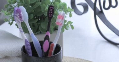 Yakından bakınca erkek eli plastik diş fırçalarını değiştiriyor.