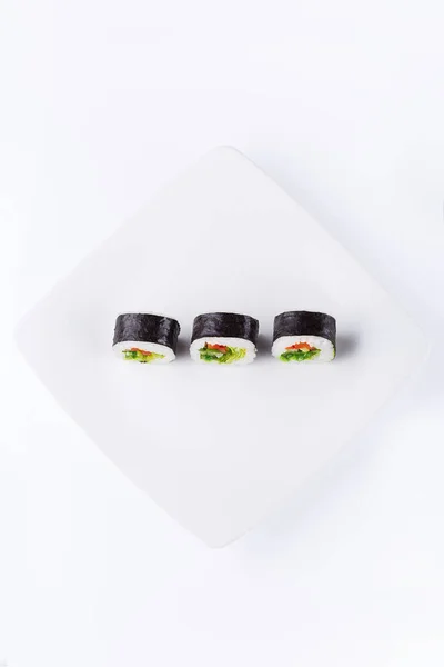 Trzy Sushi Białym Kwadratowym Talerzu Jasnym Tle Widok Góry — Zdjęcie stockowe