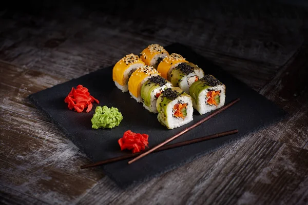 Sushi Ustawione Kwadratowej Czarnej Płytce Kamienia Imbir Pałeczki Obok Planu — Zdjęcie stockowe