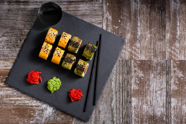 Sushi Ustawione Kwadratowej Czarnej Płytce Kamienia Imbir Pałeczki Obok Planu — Zdjęcie stockowe