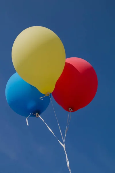 Воздушные шары трех цветов и голубого неба — стоковое фото