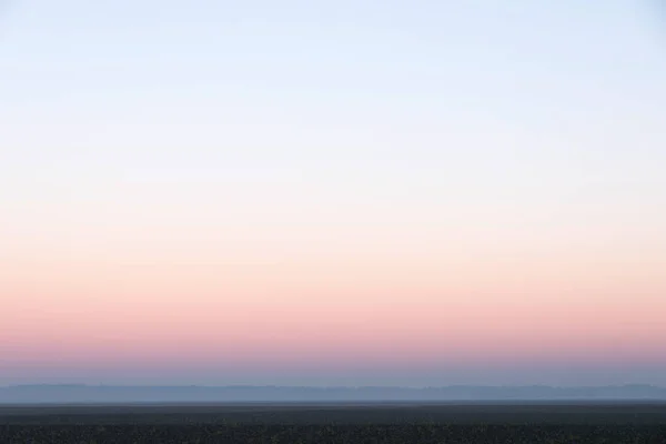 Light evening sky with pink afterglow and fog — Stock Photo, Image