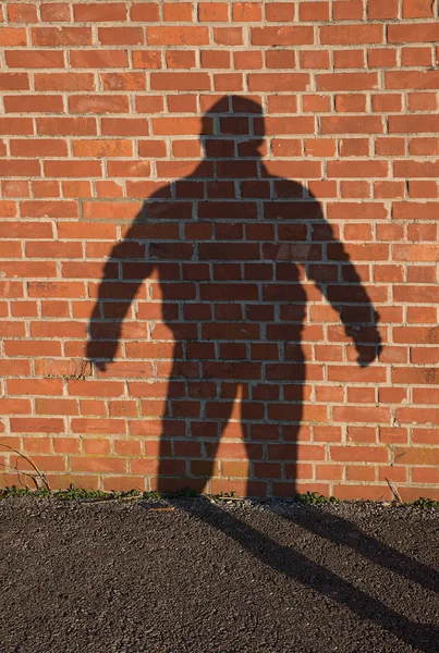 Schatten eines Mannes auf einer Ziegelmauer — Stockfoto