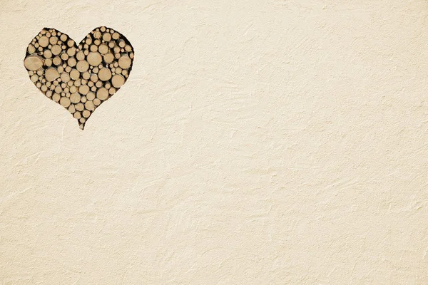 Raue beige bemalte Wand mit Holzherz — Stockfoto