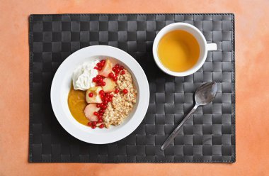 bir fincan çay ve krem ve ber ile yulaf lapası ile kahvaltı tabağı