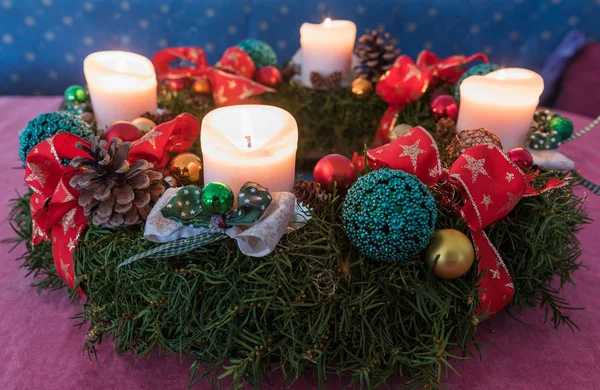Adventskranz mit vier brennenden weißen Kerzen und roten Bändern — Stockfoto