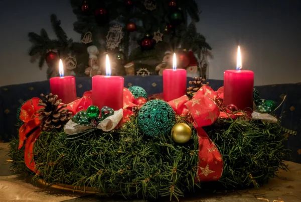 Corona de adviento con cuatro velas rojas encendidas — Foto de Stock