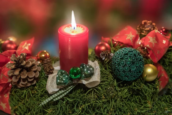 Stimmungsvolles Weihnachtsspray mit brennender roter Kerze, Schleife und — Stockfoto