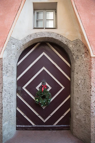 Porta storica di una piccola casa, con corona d'avvento natale d — Foto Stock