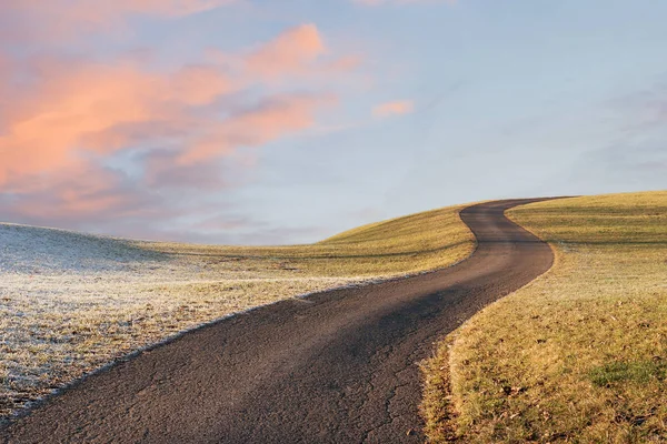 Gewundenen Weg auf dem Hügel, Morgenlandschaft mit rosa Wolken und — Stockfoto