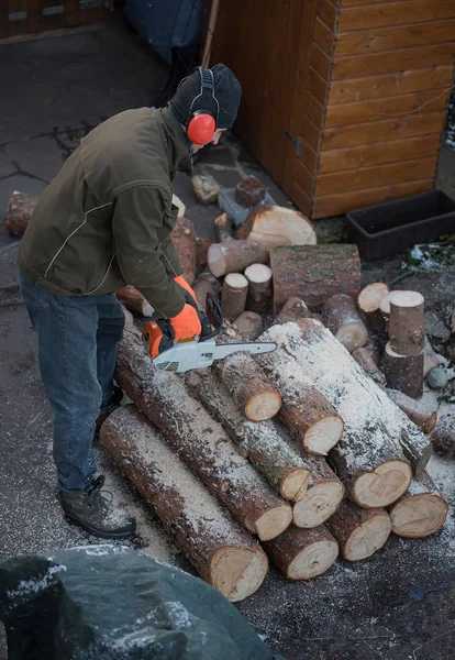 Hombre cortando troncos con una motosierra — Foto de Stock