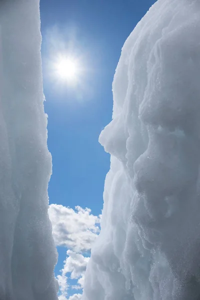 Vista attraverso un crepaccio nel cielo blu con sole e nuvole — Foto Stock