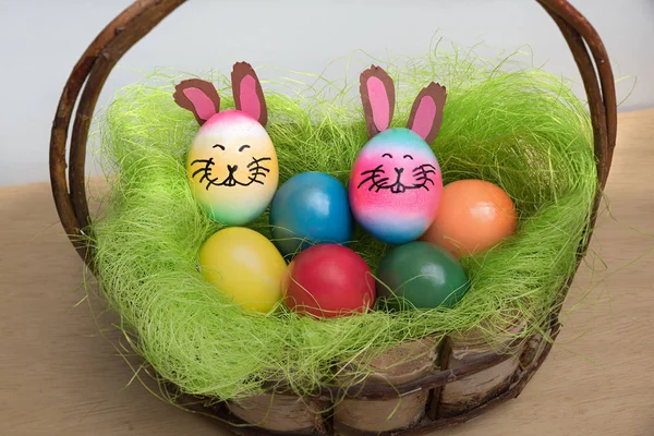 Деревенская пасхальная корзина с красочными яйцами и ручной работы цветочные h — стоковое фото