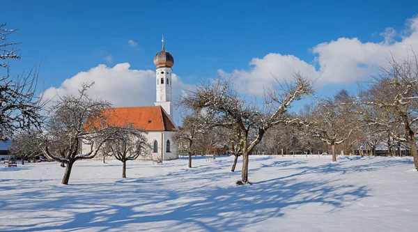 Idylický vesnický kostel a jablečný sad v zimě — Stock fotografie