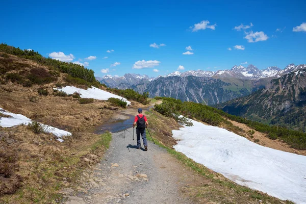 Wanderer at idyllic Fellhorn mountain trail, spring landscape in — Stock Photo, Image