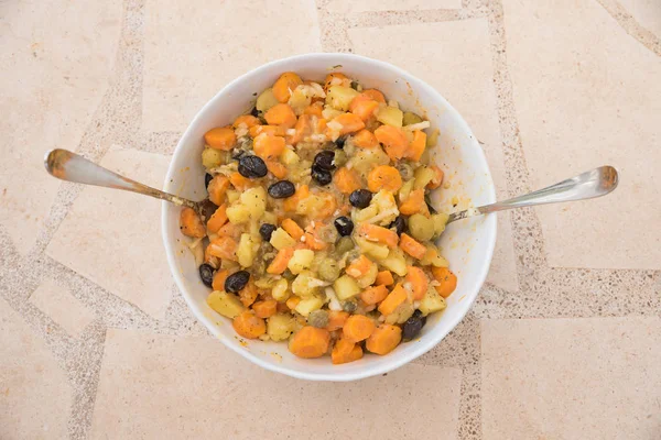Potato salad with carrots and olives in a white porcelain bowl, — Stock Photo, Image