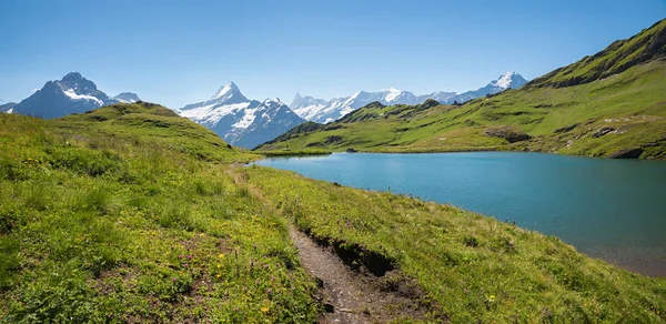 Pequena trilha em torno do idílico lago alpino Bachalpsee, destino turístico — Fotografia de Stock