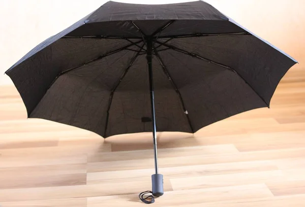 Schwarzer Regenschirm Isoliert Auf Holzhintergrund — Stockfoto