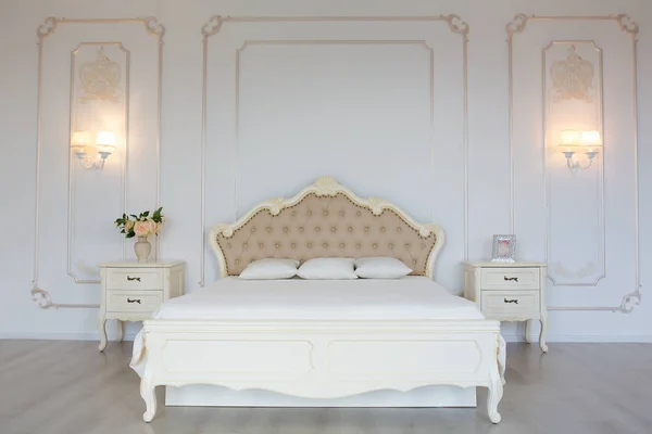 Спальня в мягких светлых тонах. большая удобная двуспальная кровать в элегантной классической спальне — стоковое фото