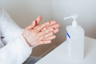 Coronavirus veya COVID-19 önleme kavramı. Doktor ellerini dezenfektan ya da pompa şişesinden alkol jeli kullanarak kapat..