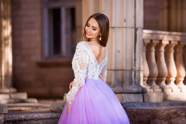 Portrait of elegant young woman with long hair and perfect smile on old building background — Stock Photo, Image