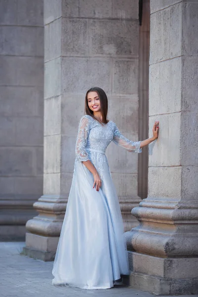 Ritratto di giovane donna elegante con capelli lunghi e sorriso perfetto su sfondo vecchio edificio — Foto Stock