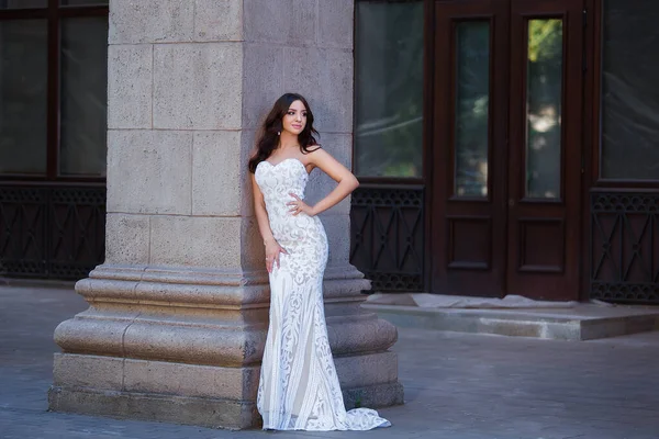 Fashion outdoor photo of beautiful sensual girl with dark hair in elegant dress posing in ancient architecture. — Stock Photo, Image