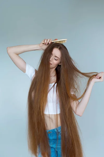 Concept of hair loss. Close up portrait of unhappy sad stressed young woman with long dry brown hair, isolated on grey background. — Stock Photo, Image