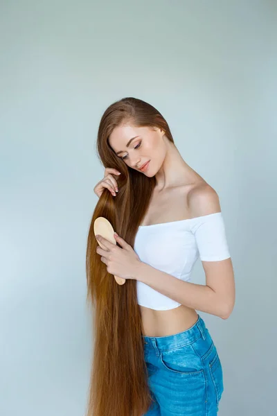Beleza close-up retrato de bela jovem com cabelos castanhos longos no fundo branco. Conceito de cuidados capilares . — Fotografia de Stock