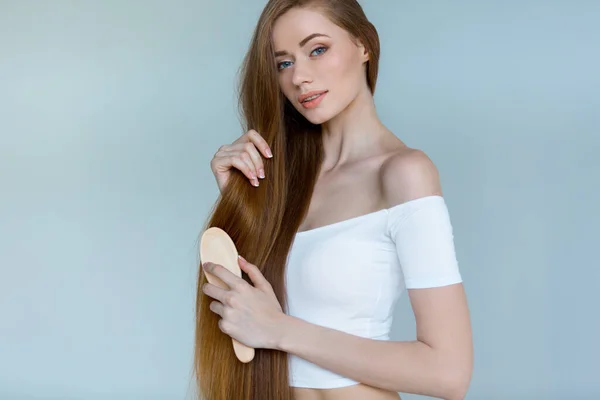 Concept of hair loss. Close up portrait of unhappy sad stressed young woman with long dry brown hair, isolated on grey background. — Stock Photo, Image