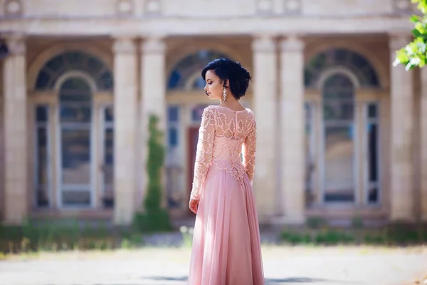 Retrato de mujer joven elegante con el pelo largo y sonrisa perfecta en el fondo del edificio viejo —  Fotos de Stock