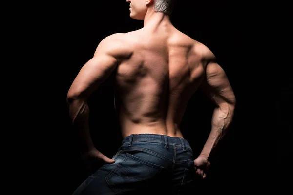 Handsome power athletic man in dramatic light. Strong bodybuilder with perfect shoulders, biceps, triceps, back, delta and chest. Strength and motivation. Bottom view — Stock Photo, Image