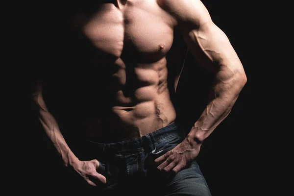 Concepto fitness. Torso muscular y en forma de hombre joven con abdominales perfectos, bíceps y pecho. Hombre hunk con cuerpo atlético sobre fondo negro — Foto de Stock