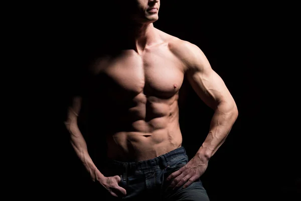 Concepto fitness. Torso muscular y en forma de hombre joven con abdominales perfectos, bíceps y pecho. Hombre hunk con cuerpo atlético sobre fondo negro — Foto de Stock