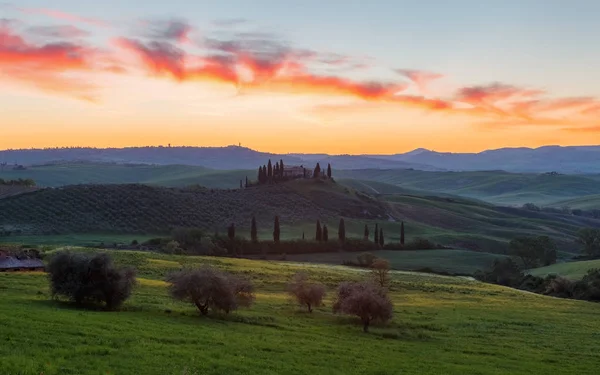 Bauernhaus, grüne Hügel, Zypressen in der Toskana bei Sonnenuntergang — Stockfoto