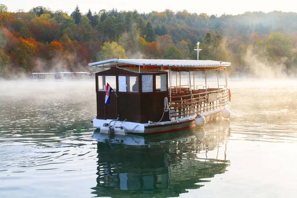 Plitvice Gölleri gündoğumu üzerinde nehir botu — Stok fotoğraf