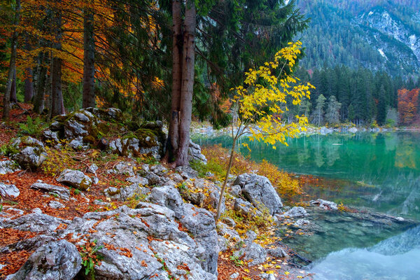 Beautiful Lago di Fusine mountain lake in autumn and Mangart mou