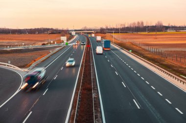 Güzel gün batımında hızlı giden araçlarla dolu bir otoyol.