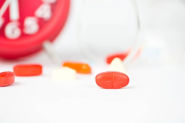Medikamententablette, Spendeglas und rote Uhr zeigen Medizin an — Stockfoto