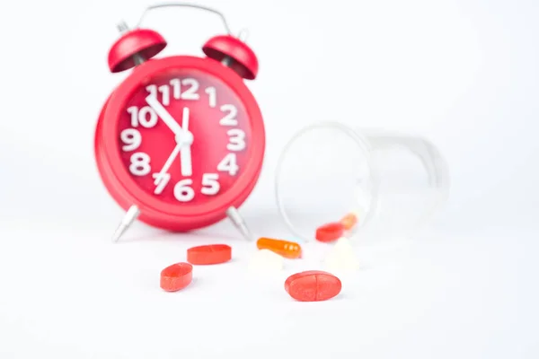Red tabets and glass on red clock — Stock Photo, Image