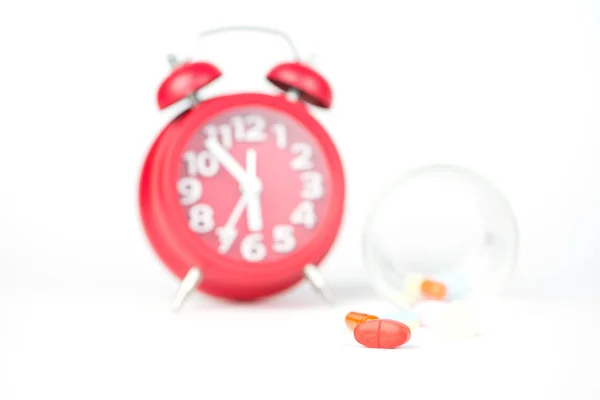 Pastillas de medicamentos, vidrio dispensador y reloj rojo muestran medicina ti — Foto de Stock
