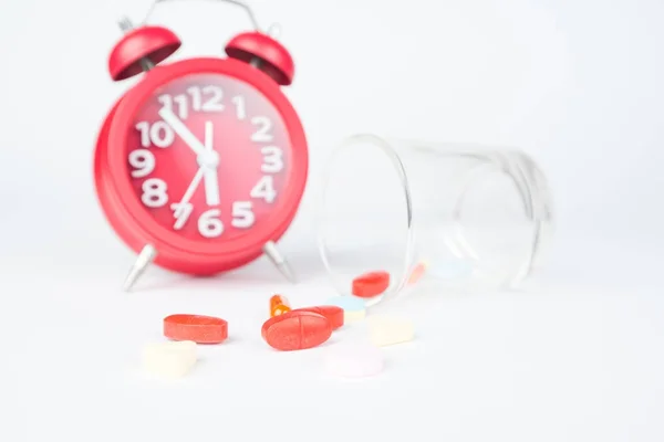 Red tabets and glass on red clock — Stock Photo, Image