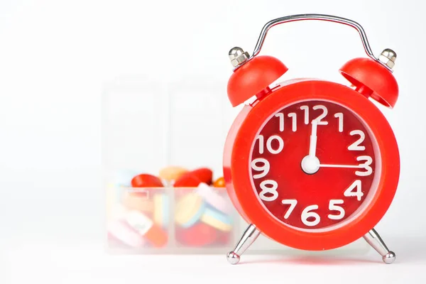 Red alarm clock and pill box show medicine concept — Stock Photo, Image