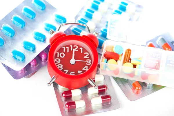 Red alarm clock and medical blister pack — Stock Photo, Image