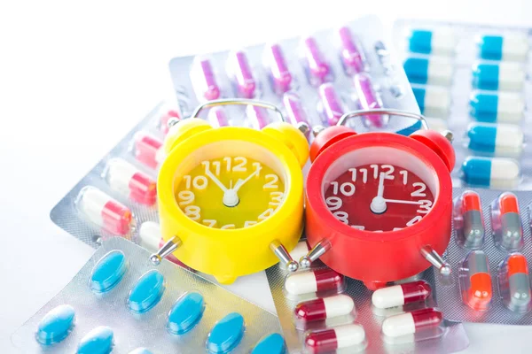 Alarm clock on medical blister pack show medicine time — Stock Photo, Image