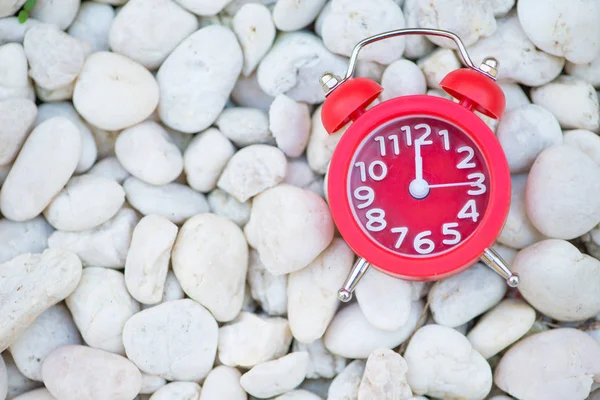 Reloj despertador rojo sobre roca blanca — Foto de Stock